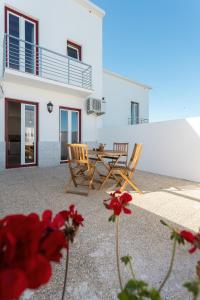 eine Terrasse mit einem Tisch und Stühlen vor einem Haus in der Unterkunft Mood Lodging - Óbidos in Óbidos