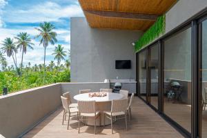 a patio with a table and chairs on a balcony at Kanui Garden Milagres in São Miguel dos Milagres
