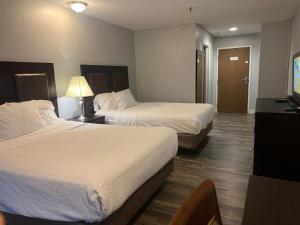Habitación de hotel con 2 camas y TV en Venture Inn Hotel en Saskatoon