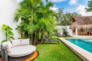 un patio trasero con piscina, una silla y una mesa en Villa Ek'Balam & Villa Flamingo, Luxury Villas, Private Pool, Private Garden, Jacuzzi, 24h Security en Tulum