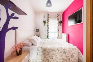 a bedroom with a bed with a pink wall at ESPECIAL para GRUPOS a 3 paradas del metro Atocha in Madrid