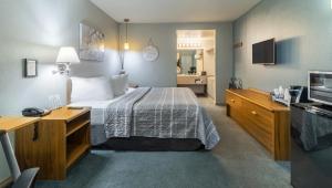 a hotel room with a bed and a television at Resort City Inn Coeur d Alene in Coeur d'Alene