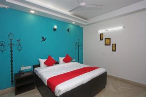 ein Schlafzimmer mit einem großen Bett mit blauer Wand in der Unterkunft OYO Maira Stays in Indraprast