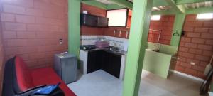 uma pequena cozinha com uma parede de tijolos vermelhos em Mi pueblo natal Aptos y habitaciones em Necoclí
