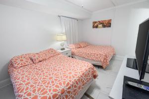 une chambre d'hôtel avec deux lits et une télévision dans l'établissement Island Winds East 308 by ALBVR - Beautifully renovated beachfront condo & steps away from Hangout & more!, à Gulf Shores 34 autres photos