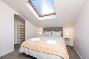 ein Schlafzimmer mit einem Bett und einem Dachfenster in der Unterkunft Inner City Apartment in Wellington