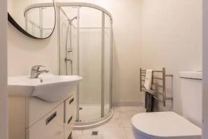 a bathroom with a shower and a sink and a toilet at Inner City Apartment in Wellington