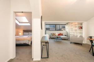 Inner City Apartment في ويلينغتون: غرفة نوم مع سرير وغرفة معيشة