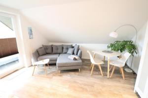- un salon avec un canapé et une table dans l'établissement Appartementhaus-Kogge-Wohnung-7, à Cuxhaven