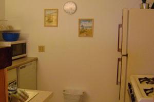 una cucina con frigorifero e orologio sul muro di Suite Breeze Beach Vacation Rental - one bedroom apartment. a Morro Bay