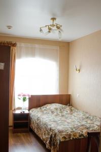 a bedroom with a bed and a window at Baker Street Hotel in Nizhny Novgorod