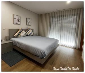 een slaapkamer met een groot bed en een raam bij Casa Couto Do Souto in Souto