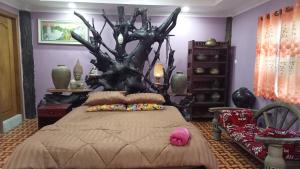 a bedroom with a bed with a tree behind it at Kakrona Pouk Homestay in Siem Reap