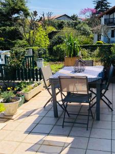 einen Picknicktisch und zwei Stühle auf einer Terrasse in der Unterkunft La terrasse à Erromardie in Saint-Jean-de-Luz