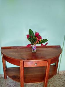 uma mesa com um vaso de flores em cima em Casa Hotel Familiar 