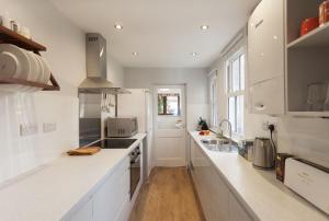 een witte keuken met witte werkbladen en een wastafel bij Highfield Grove in Nottingham