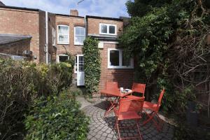 a patio with red chairs and a table in front of a building at Highfield Grove in Nottingham