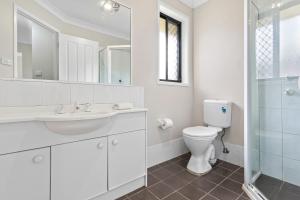 a white bathroom with a toilet and a sink at Large seven bed house in Jesmond