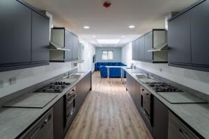 a kitchen with gray cabinets and counter tops at Spacious studio near city centre! in Birmingham