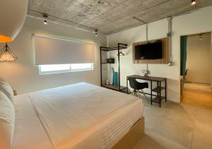 a bedroom with a large white bed and a desk at The Host Business Suites at WTC in Mexico City