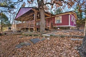 a house with a wrap around porch and a tree at Waterfront House with Boat Slip on Lake Eufaula! in Canadian