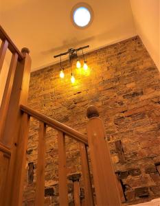 a staircase with a stone wall and a chandelier at Peaceful Cottage for Two in Horsham in Horsham