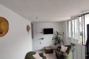 a living room with two chairs and a tv at Aparta estudio Fantástico in Bucaramanga