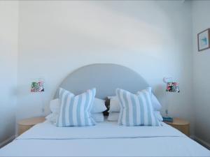 a white bed with white pillows and two lamps at Regency on the Beach in Gold Coast