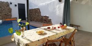 einen Tisch mit Obstschalen und einem Pool in der Unterkunft Casa Rural Abuela Maxi in Ríolobos