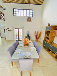 comedor con mesa y sillas azules en Casablanca Beira Mar, 5 Suítes, Praia Tabuba AL en Barra de Santo Antônio