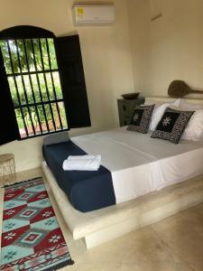 a bedroom with a large bed with a window at Casa De Amigos Hotel Boutique in Honda