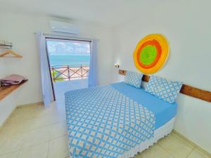 1 dormitorio con 1 cama y vistas al océano en Casablanca Beira Mar, 5 Suítes, Praia Tabuba AL en Barra de Santo Antônio