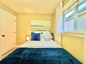 1 dormitorio con cama con sábanas azules y ventana en The Royal Suite en Surrey