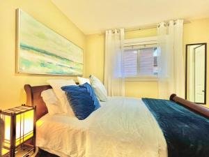 a bedroom with a white bed with blue pillows at The Royal Suite in Surrey