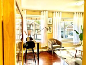 a living room with a table and chairs and windows at The Royal Suite in Surrey