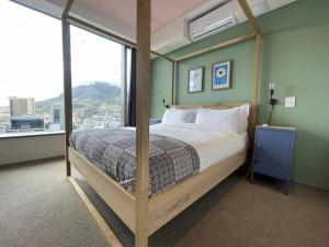 1 dormitorio con cama con dosel y ventana grande en City Center Penthouse with rooftop terrace en Ciudad del Cabo