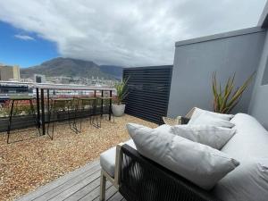 a couch on a balcony with a view of a mountain at City Center Penthouse with rooftop terrace in Cape Town