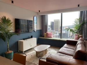 sala de estar con sofá y ventana grande en City Center Penthouse with rooftop terrace en Ciudad del Cabo