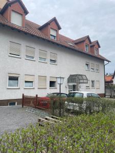 un gran edificio blanco con coches estacionados frente a él en 1 Zimmer für 2 Personen Bruchsal, en Bruchsal