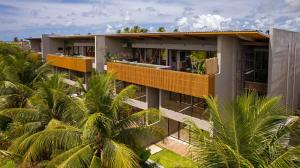 an external view of a building with palm trees at Milagres Hospedagens - Praia e Vista Coqueiros in São Miguel dos Milagres