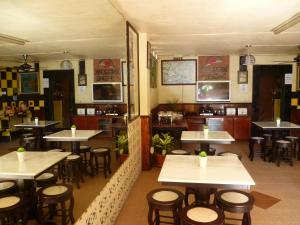 un restaurante con mesas y sillas en una habitación en Anggerik Lodging, en George Town