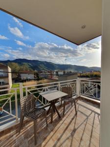 a patio with a table and chairs on a balcony at Studios Denis in Stavros