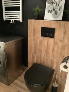 a bathroom with a black toilet and a sink at Blu Apartament 6 Cetniewo Osada in Władysławowo