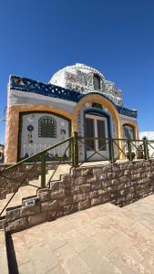 un edificio con una cúpula sobre una pared de piedra en Artika Wadi Kiki Hotel en Asuán