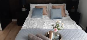 a bed with white sheets and blue pillows at Blu Apartament 6 Cetniewo Osada in Władysławowo