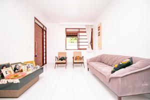 a living room with a pink couch and chairs at Casa em Campina Grande in Campina Grande