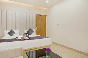 a room at a hotel with a bed and a table at Super Townhouse 1149 Hotel Impact in Chinhat