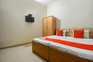 a bedroom with a large bed with orange pillows at OYO Sabtera Homes in Kharar