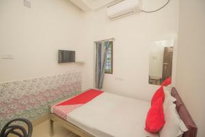 niewielka sypialnia z łóżkiem i oknem w obiekcie OYO Hotel Kshounish Residency w mieście Māldah