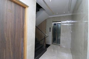 a hallway with a door and stairs in a building at Hotel Hiland International Near Acropolis Mall in Jādabpur